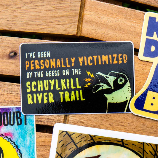 Sticker with text saying "I've been personally victimized by the geese on the Schuylkill River Trail" with a goose hissing.