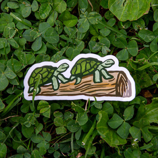 Two turtles smiling on a log sticker