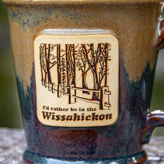 Mug with clay plaque featuring a forest design and text 'I'd rather be in the Wissahickon'.