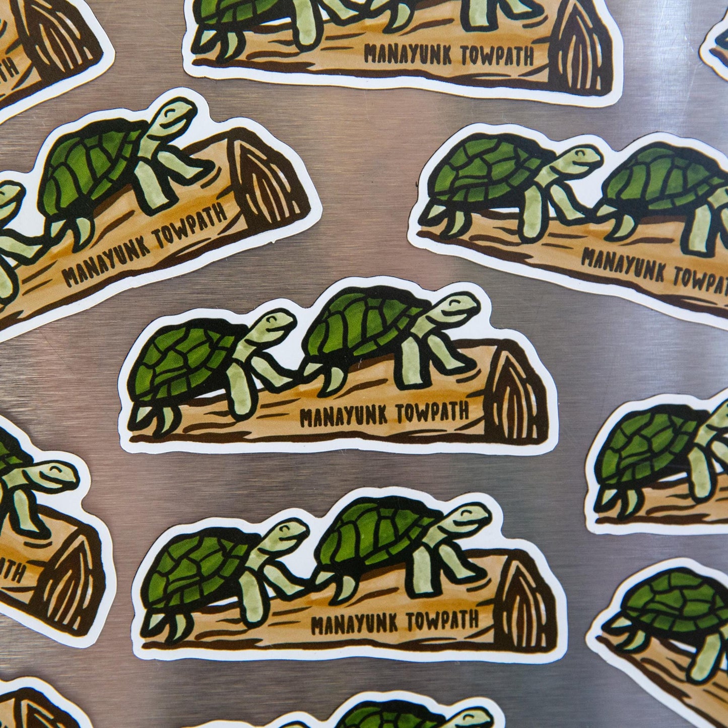 Mutiple turtle on a log magnets on a metallic background.