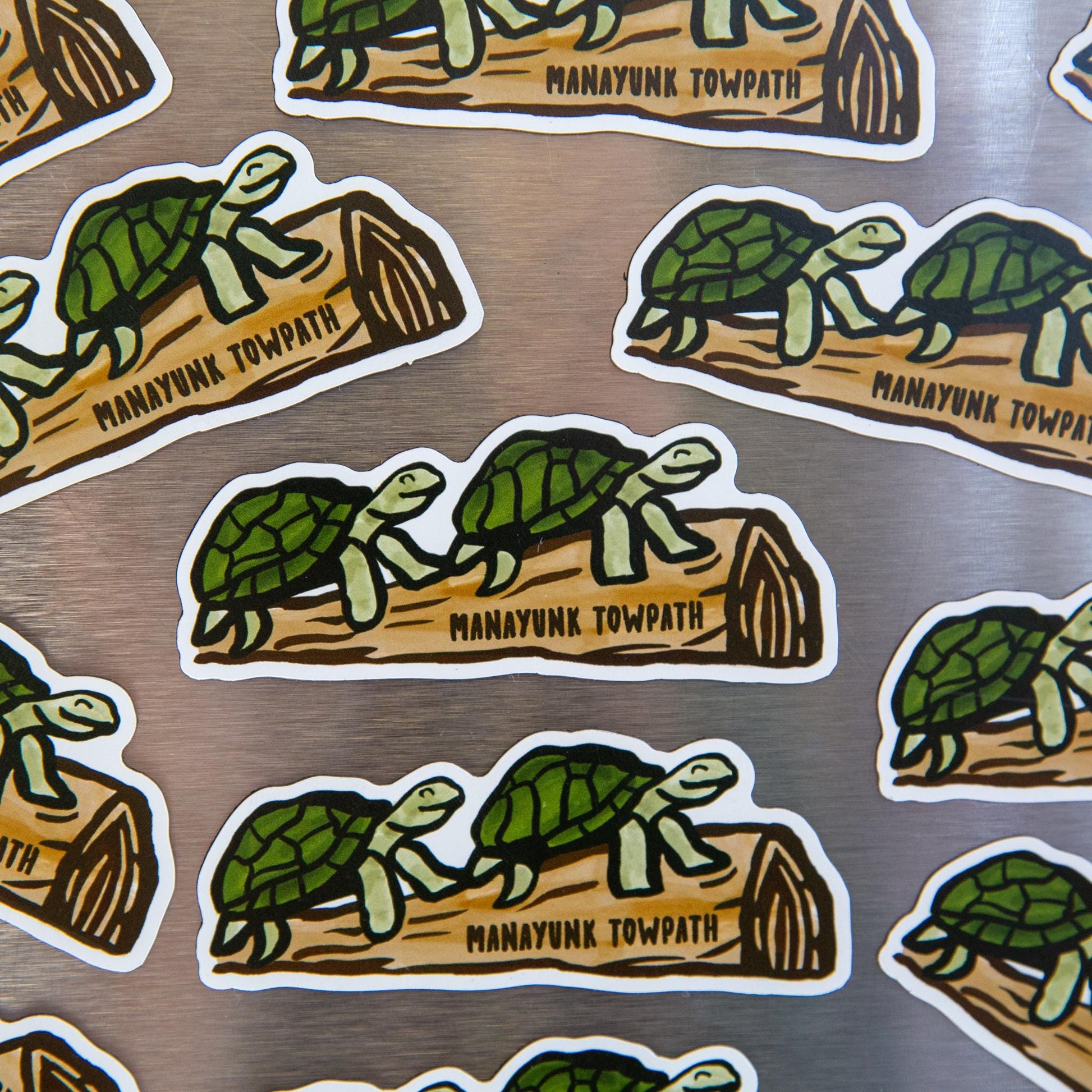 Mutiple turtle on a log magnets on a metallic background.