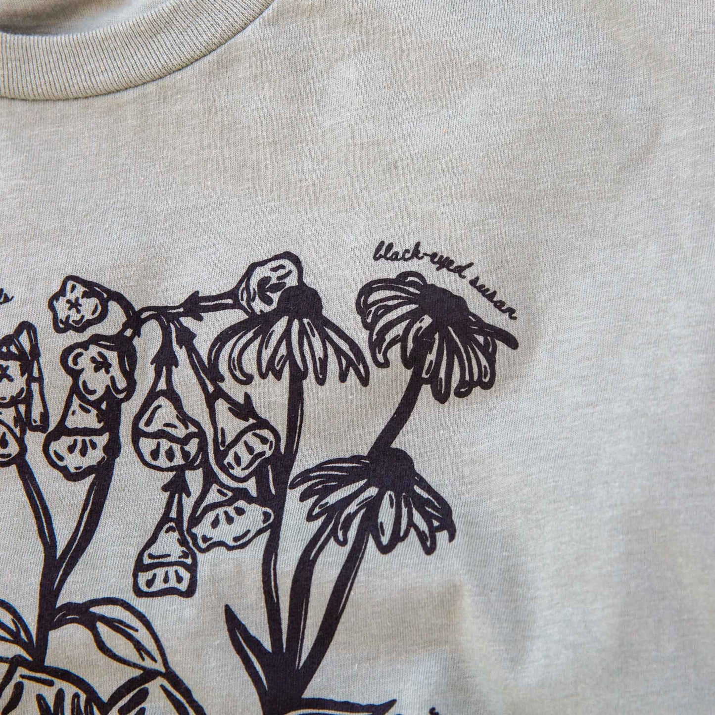 Black floral illustration on a sage background with 'black-eye susan' text.