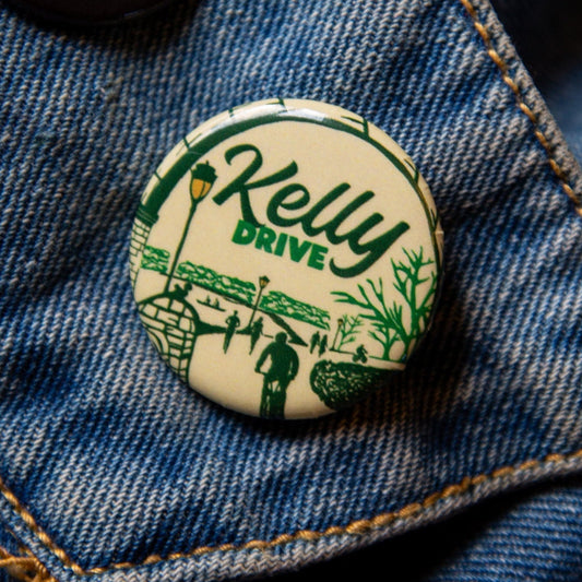 Button with 'Kelly Drive' design on a denim jacket
