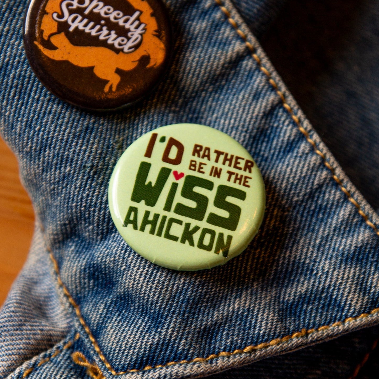 Green button on a denim jacket, with 'I'd Rather be in the Wissahickon' text