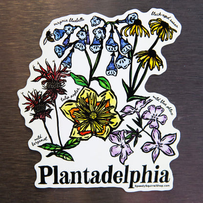 Fridge magnet with colorful flowers and 'Plantadelphia' text on a metallic surface