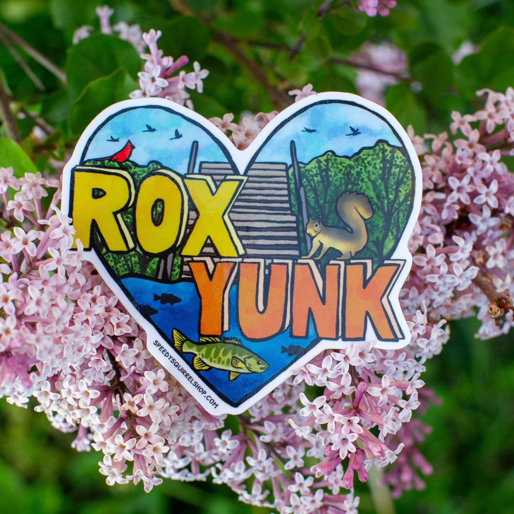 Heart-shaped sticker with 'ROX YUNK' text on a background of pink flowers