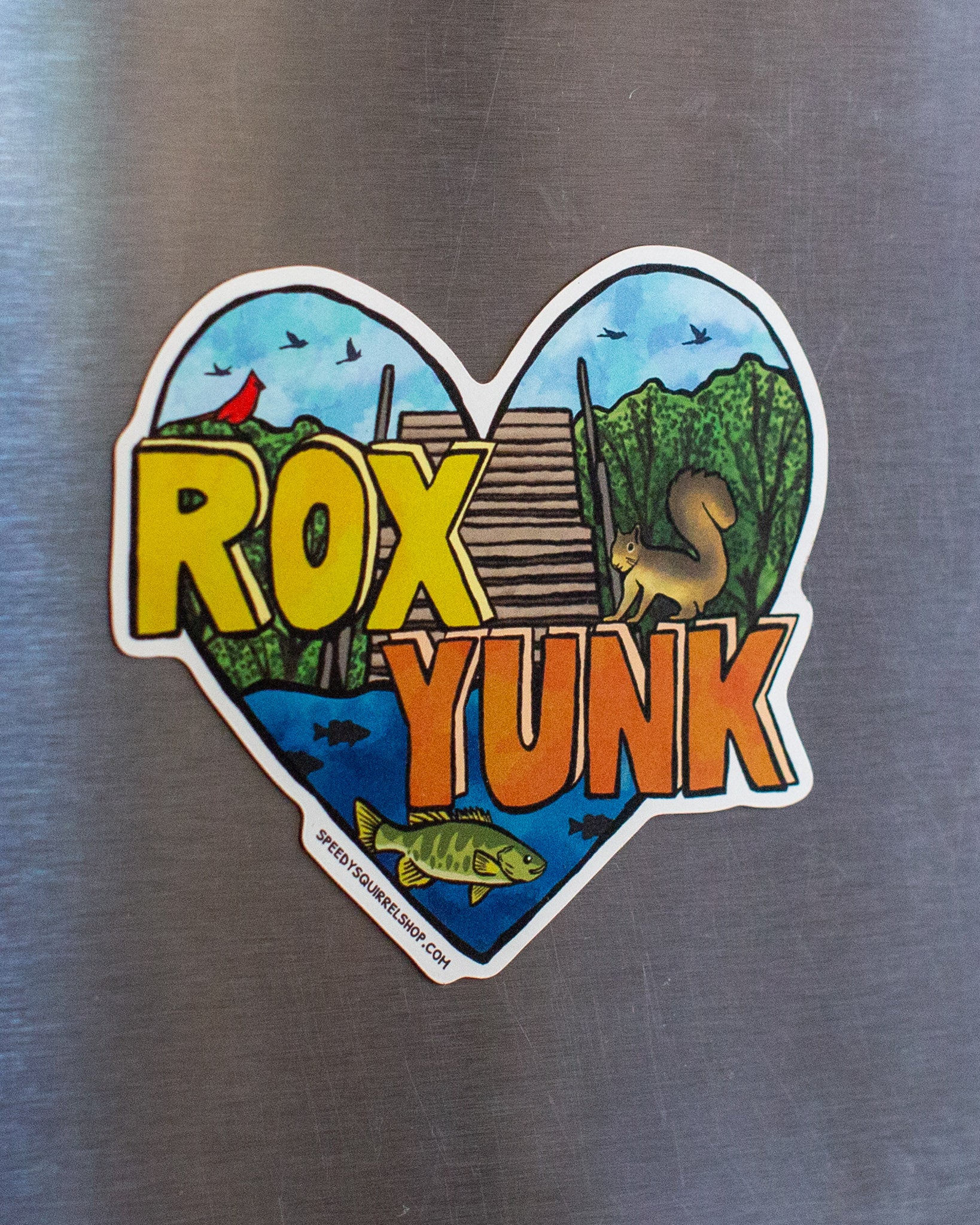 Heart-shaped sticker with 'ROX YUNK' text on a metallic surface