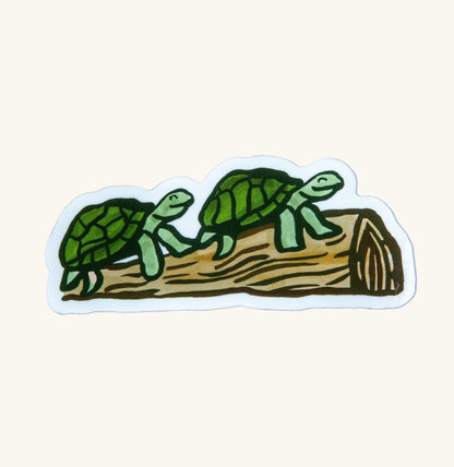 Two turtles smiling on a log sticker