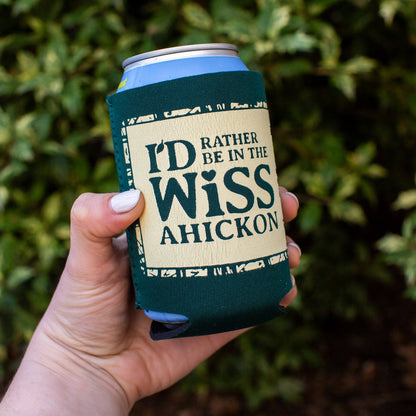 Hand holding a can with 'I'd Rather Be in the Wissahickon' text against a green leafy background
