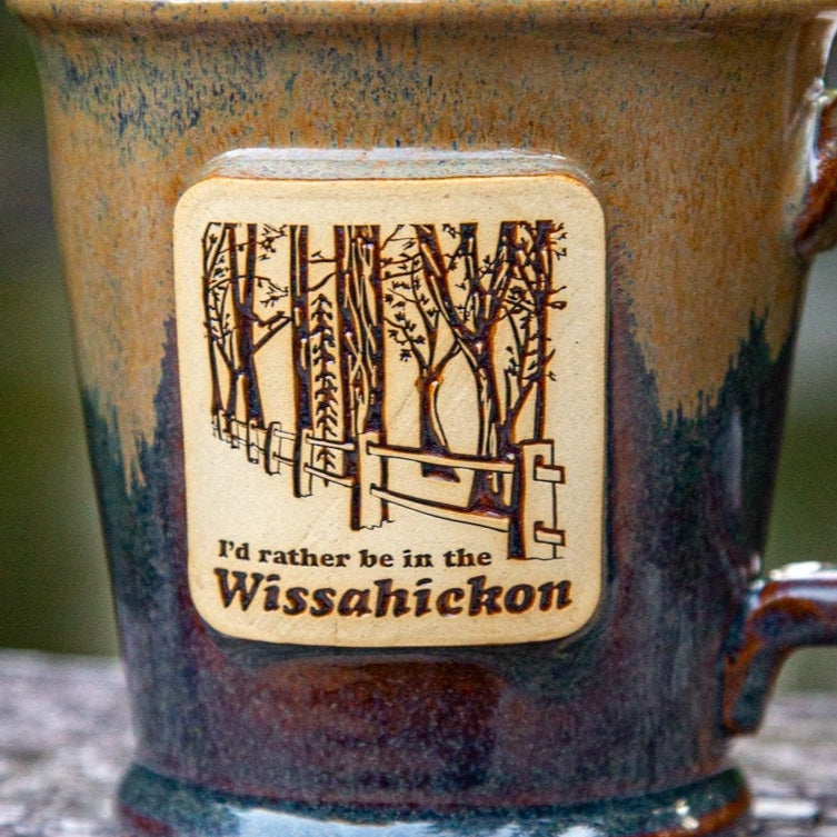 Mug with clay plaque featuring a forest design and text 'I'd rather be in the Wissahickon'.