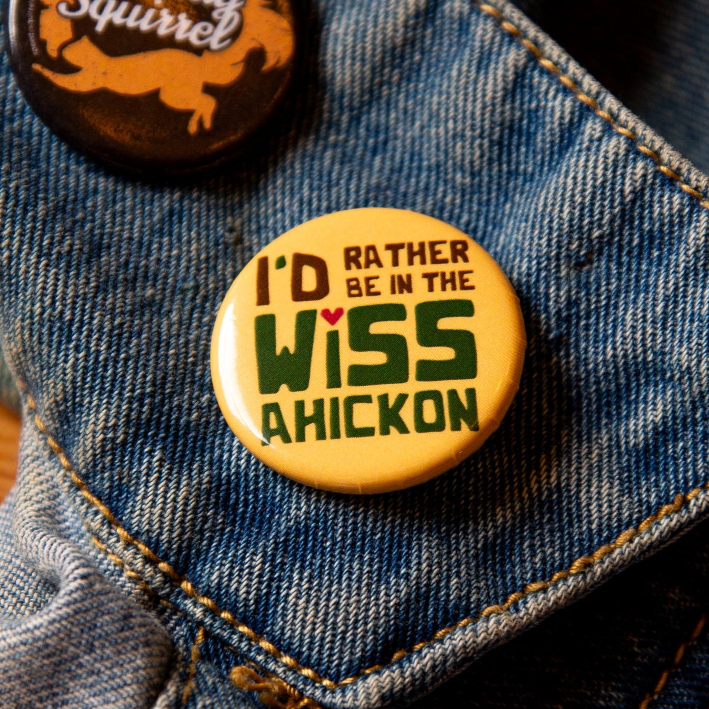 Yellow button on a denim jacket, with 'I'd Rather be in the Wissahickon' text